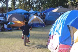 A young boy rides his bike through the maze of tents at the Calistoga evacuation site.
