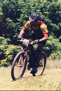 Paul Ippolito bikes on a grassy trail.