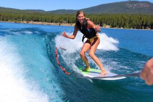 Junior Jacqueline Racich rides on a wake surf board in Tahoe. 