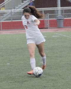 Junior Lily Armstrong dribbles the ball in the rain.
