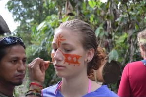 Un guÍa muestra a Hartwell uno de los usos del achiote, para teñir la piel, en el bosque lluvioso de la amazonía a lado del Río Napo.