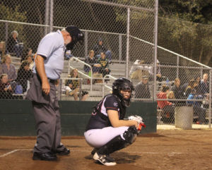 Attentively calling pitches, junior Mandy Weitenhagen takes a quick look to the dugout.