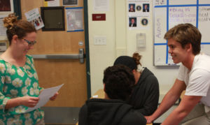 Working with her Government students, Ms. Kornfeld circulates the classroom to check in with table groups. 