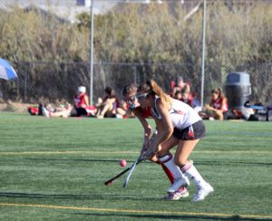 Fighting for the ball, junior Erin McCarthy crosses sticks with a defender.