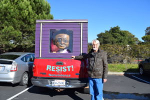 Posing next to his semi-famous Gandhi mobile, Jes Richardson, substitute teacher, is also a well known peace and human rights activist.