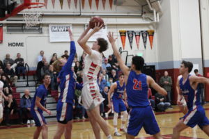 Junior Jack Gerson jumps to make a basket for the Giants at the boys' varsity basketball game against Tam on Tuesday.