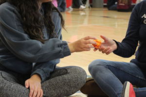 Passing a paper ball, students learn each others name through a group game.