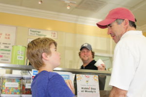 Ordering ice cream, 1984 Redwood varsity swim team captain, Chuck Muller, and his son, Charlie Muller, debate over ice cream sizes to order.