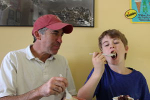 Enjoying their ice cream from Woody's Yogurt Place, Chuck Muller watches his son, Charlie Muller, indulge in a large bite of his cookies and creme ice cream order, topped with peanut butter cups and brownies. 