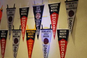 The walls, clad with pennants earned by athletes, exhibit the successes of various teams.