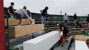 Nordstrom and his friends paint wood boxes on the bleachers to revamp Endriss field