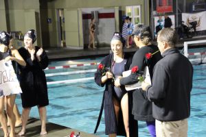 Coach Kirsten Frazer hands out roses and posters to senior players on Senior Night
