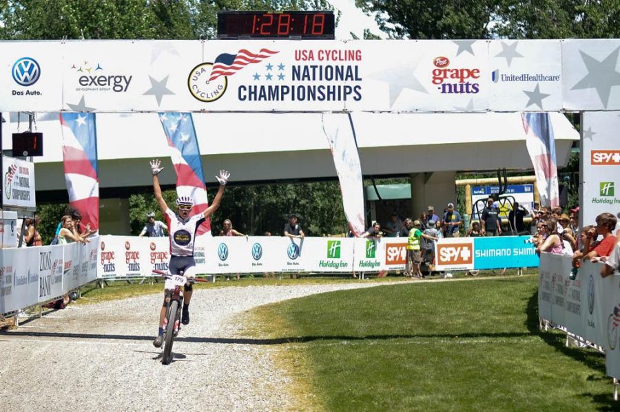 Marcus Segedin raises his arms in the universal symbol for victory as he crosses the finish line to win the USA Cycling national championship cross country race, category 1, age 15-16.