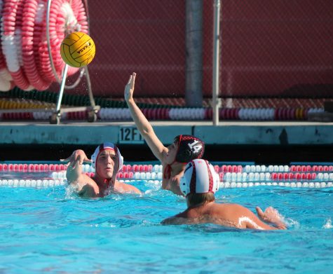 A Redwood defender pressures a Marin Academy player in the season opening varsity water polo match on Sept. 5 at the Redwood pool.