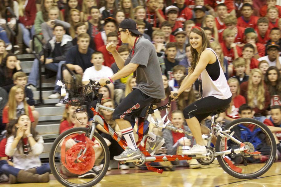 Homecoming Court Canditates Douglas Pardella and Celeste Carswell round the gym on a tandem bicycle.