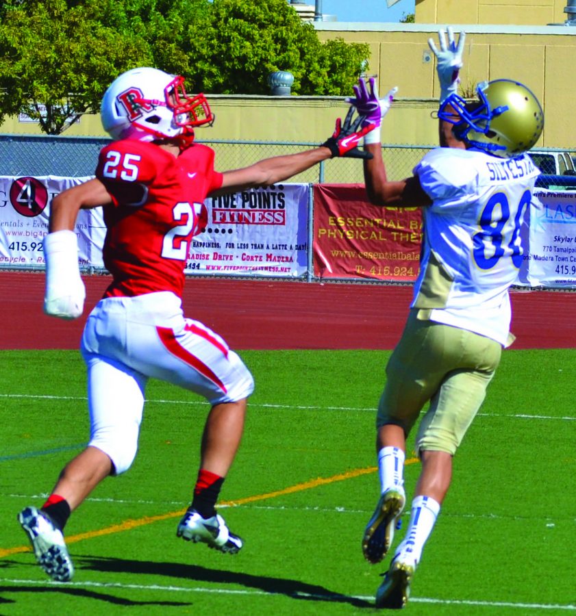Brian Hunca, playing with a cast on his injured hand, swats away a ball in a football game against San Marin. 