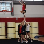 Cheerleaders practice their routine during a practice in the small gym.