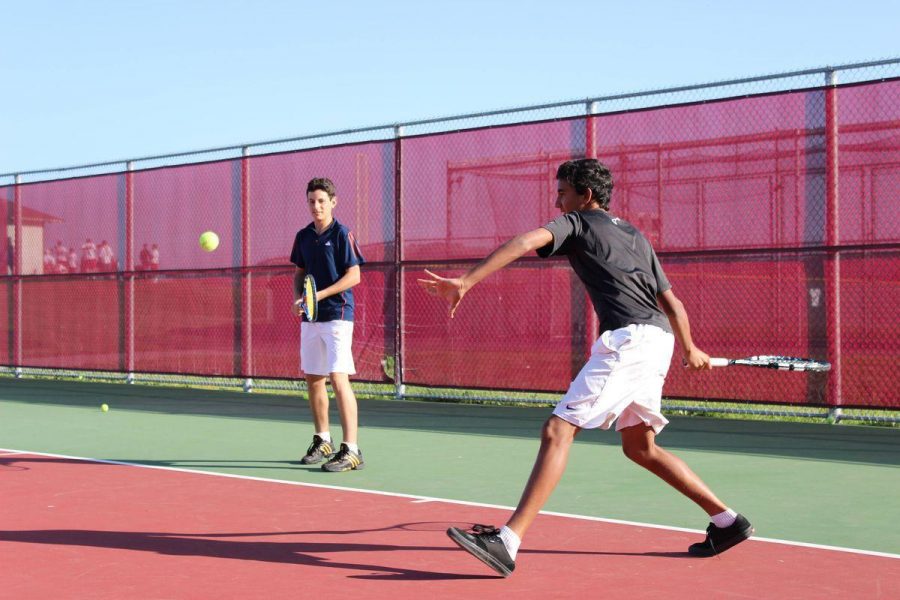 Freshmen  Cengiz Aksu and Dominic Barretto warm up before practice on the Redwood tennis courts.  The two players are third and fourth on the team ladder, respectively.