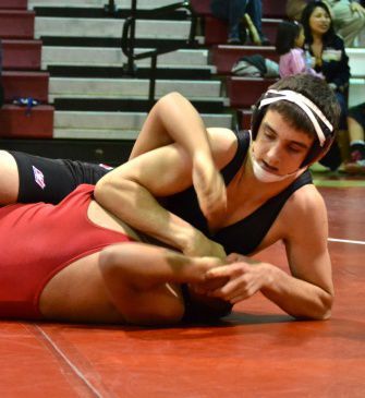 Junior Nathan Morris pins down an oppenent at a wrestling match in late February.