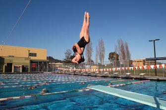 Junior Rachel Perper takes a dive into the Redwood lap pools Monday afternoon.