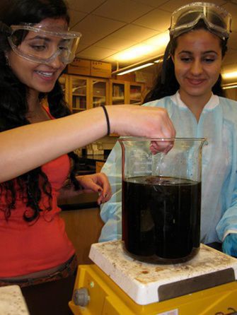 NEEKA MASHOUF (left) and Leila Mashouf (right) purify cooking oil to make biodiesel with members of their club afterschool.