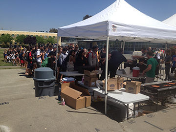 HUNGRY STUDENTS line up across the South Lawn to receive free hot dogs from Link Crew at lunch on May 3.