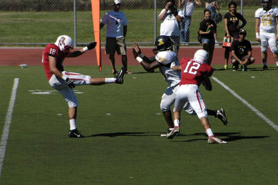 Redwood punter Zach Chayra's kick is blocked by San Marin's Max Atkins. (Photo by Drew Osher)