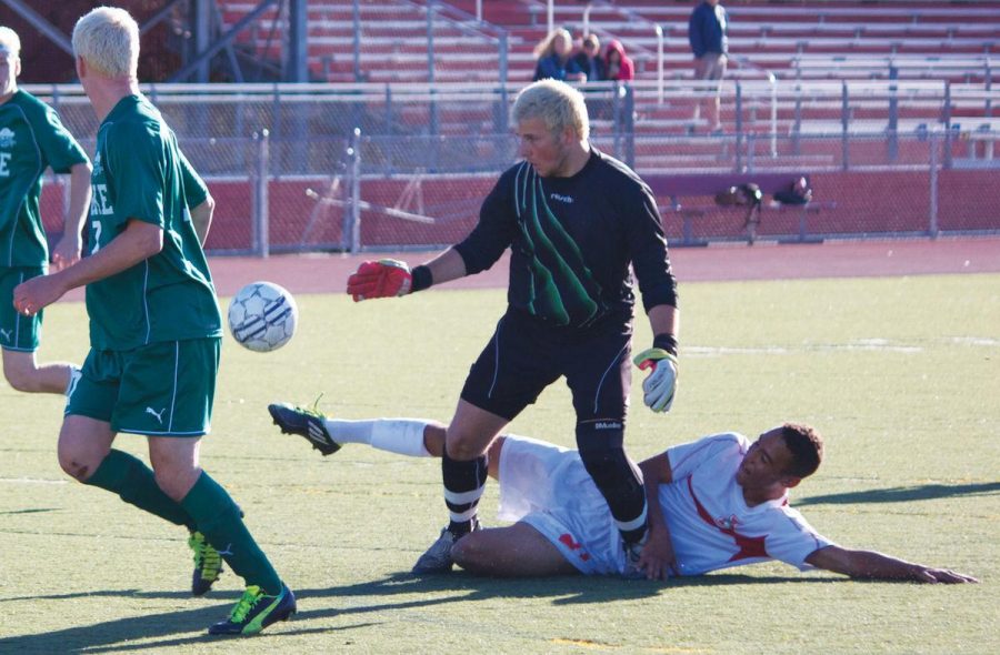 Senior Mickey Nengo contests the Drake goalkeeper for a loose ball during a match on September 25. Drake and Tam are the two most prominent rivals for the boys’ soccer team.