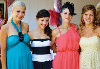 TIA AND GABI pose with their biological sisters at a wedding. 