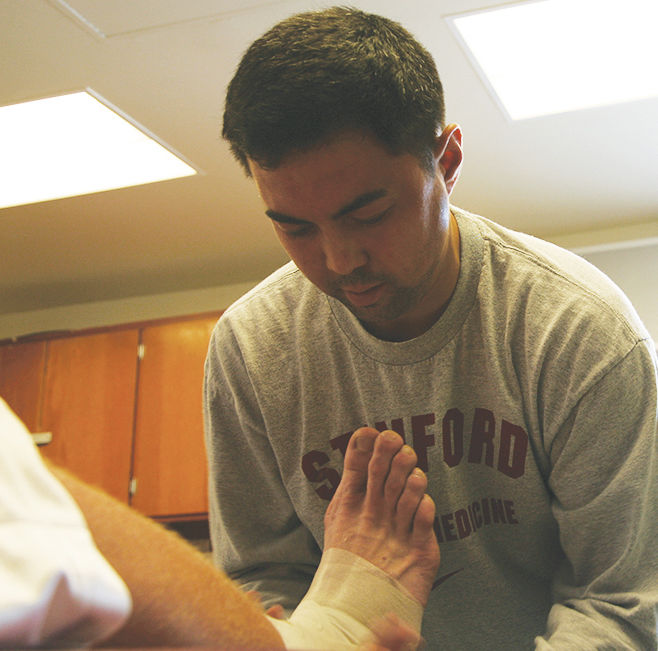 Americ Alvarado, Redwood physical therapist, bandages up an injured ankle, something junior Sander French would like to see in his idea of a sports science and medicine class. 