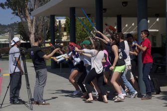 Students charge the camera while filming the April Fool’s special.