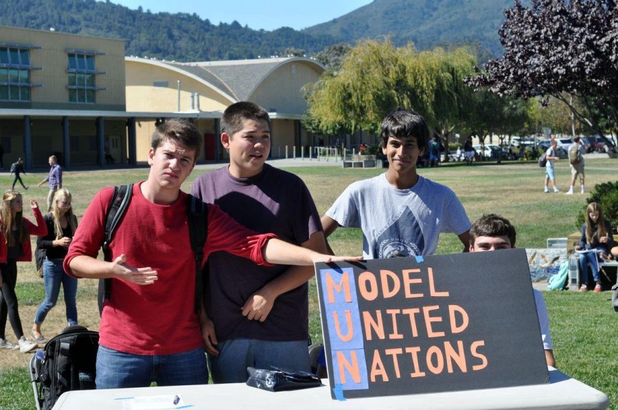 Three students show their Model United Nations sign during Club Day. 