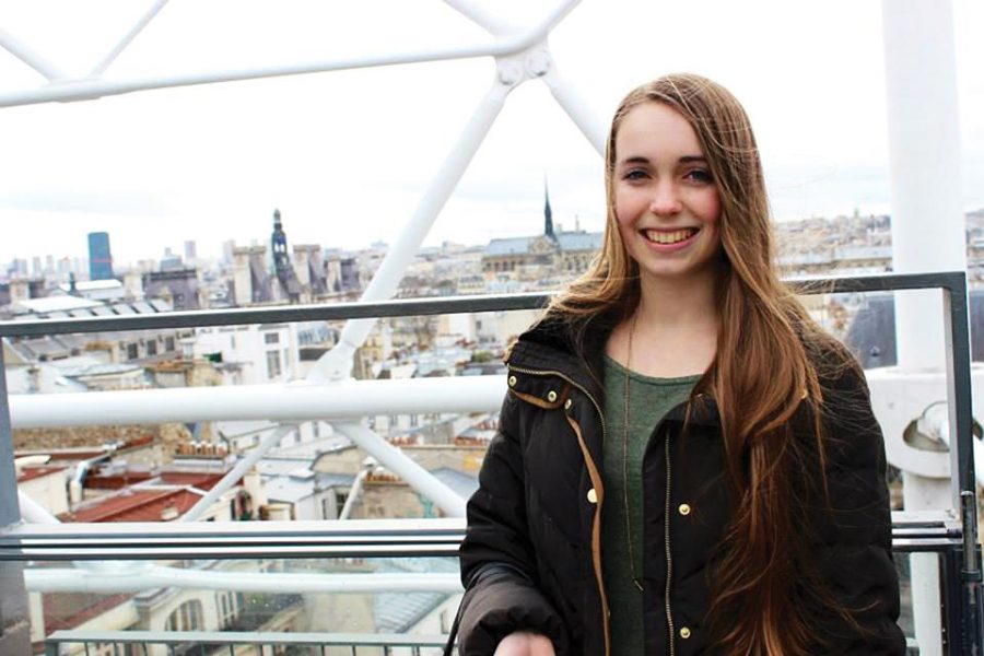 Senior Sophie Vale stops to pose for a photo in front of the Paris skyline during her year-long trip to France. 