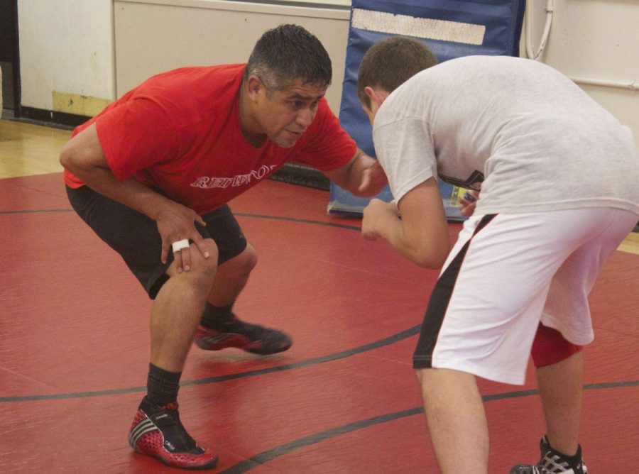 Ernesto Nuñez trains with one of his athletes in preparation for the upcoming wrestling season. 