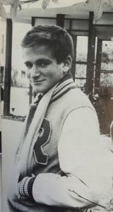 Robin Williams poses wearing his varsity letterman jacket. He was a member of the cross country, track, and soccer teams during his time at Redwood. 