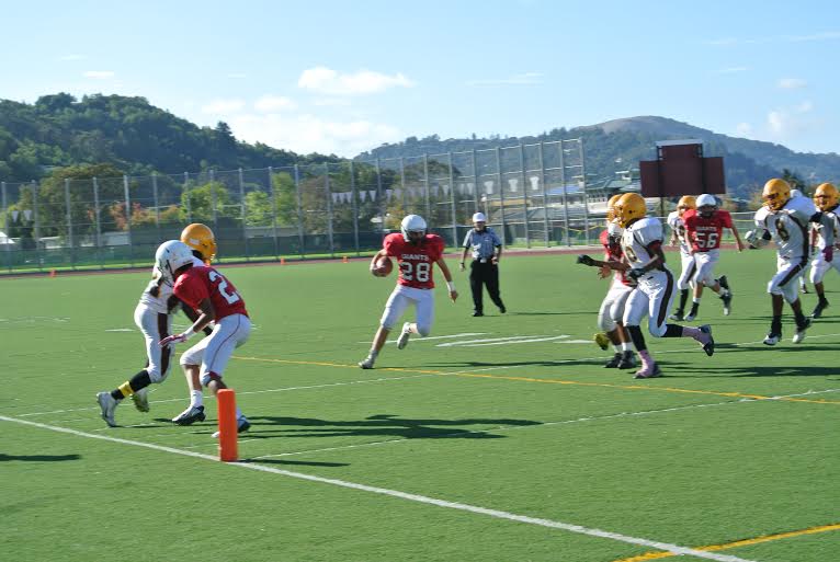 Redwood athlete takes the ball towards the end zone. 