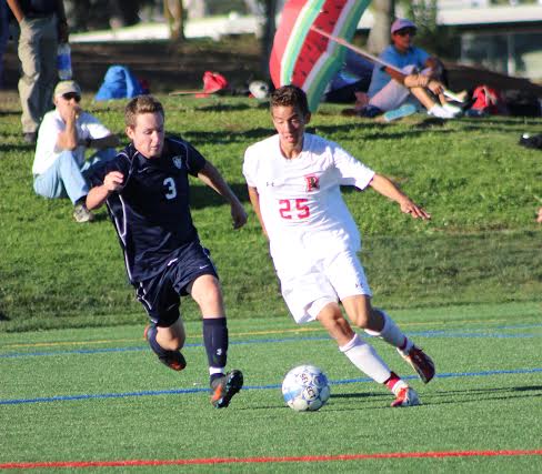 Varsity athlete dribbles the ball up the field. 