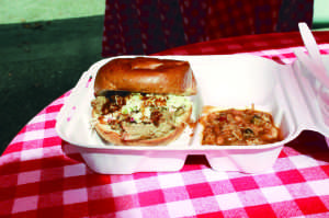 A PULLED PORK sandwich with a side of beans sits atop an outdoor table at Max’s Pig ‘n’ Pie BBQ. This food truck is located between building 400 and 500 at the Tamal Vista office complex from 11 a.m. to 2 p.m. on Thursdays. 