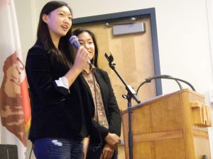 Co-presidents of Amnesty International Leah Jun and Lilly Kane-Darci speak to the audience during the dinner on Dec. 10. 
