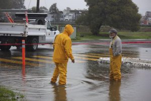 Redwood maintenance workers stand by the entrance to the flooded parking lot. 