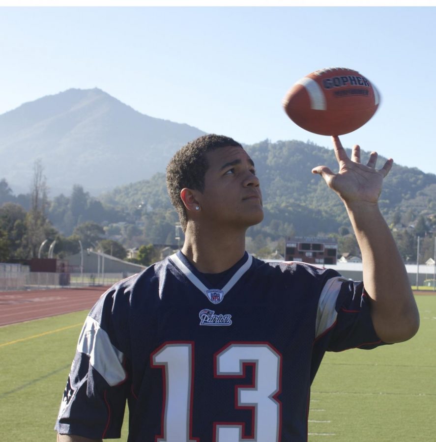 ON THE REDWOOD football field, senior Picon-Roura spins a football while wearing an authentic Patriots football jersey from his friend.