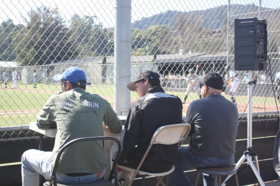 Capers Wolkom (middle) observes a Varsity baseball game