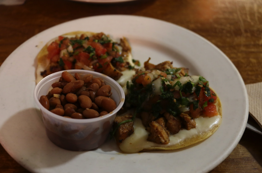 Topped with chicken, pico de gallo, onions, cilantro, and extra cheese, two grilled chicken tacos cost $3.20 at San Rafaels Picante and come with a side of pinto beans.