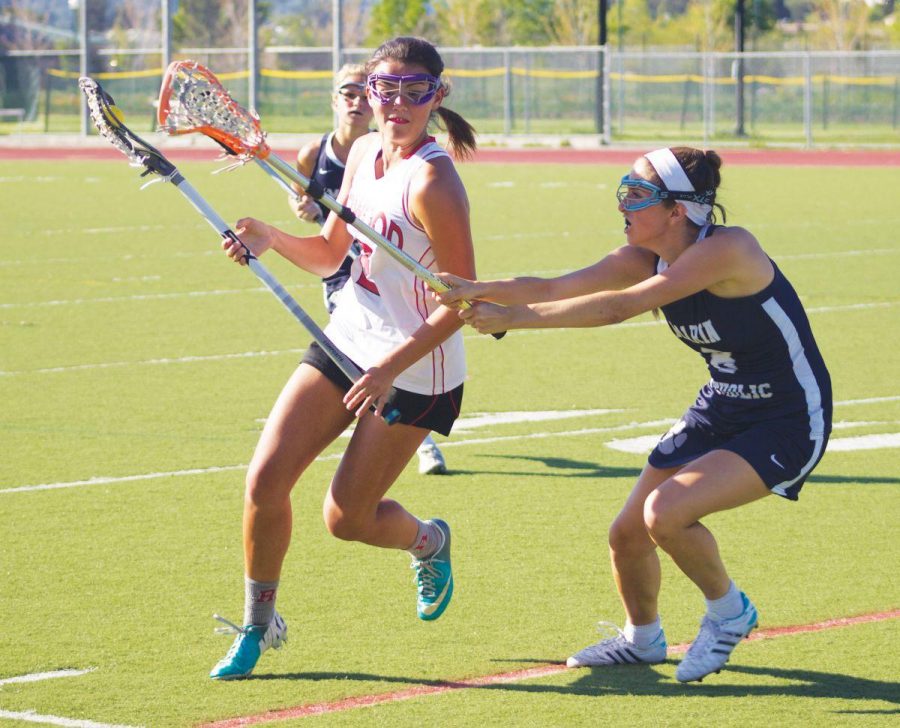 Cradling the ball, junior Kendra Loo takes on an MC opponent on Thursday, March 26, when the girls’ lacrosse team won 14-3 in a nail-biter game. The team is currently in second place in MCALs behind Novato.