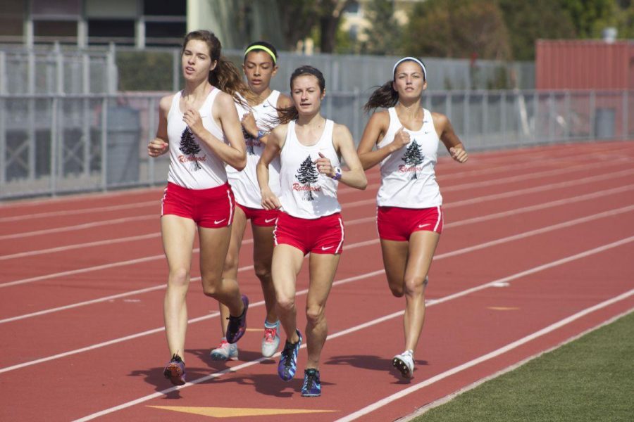 Members of the girls track team run on the Redwood track during a meet against Marin Catholic and Terra Linda. The Giants won the meet.