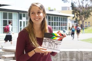 Standing with one of her clapboards from her set junior Kim Vela prepares to direct one of her manny current projects, which include 