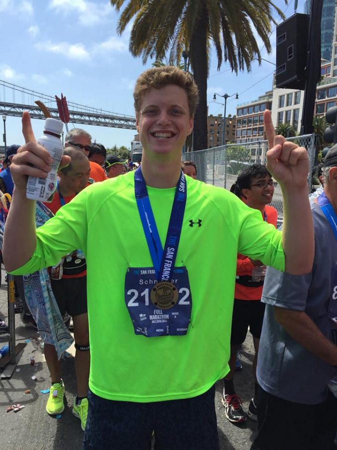 Celebrating his completion of the marathon, senior Cole Schneider smiles for the camera while sporting his new medal. 