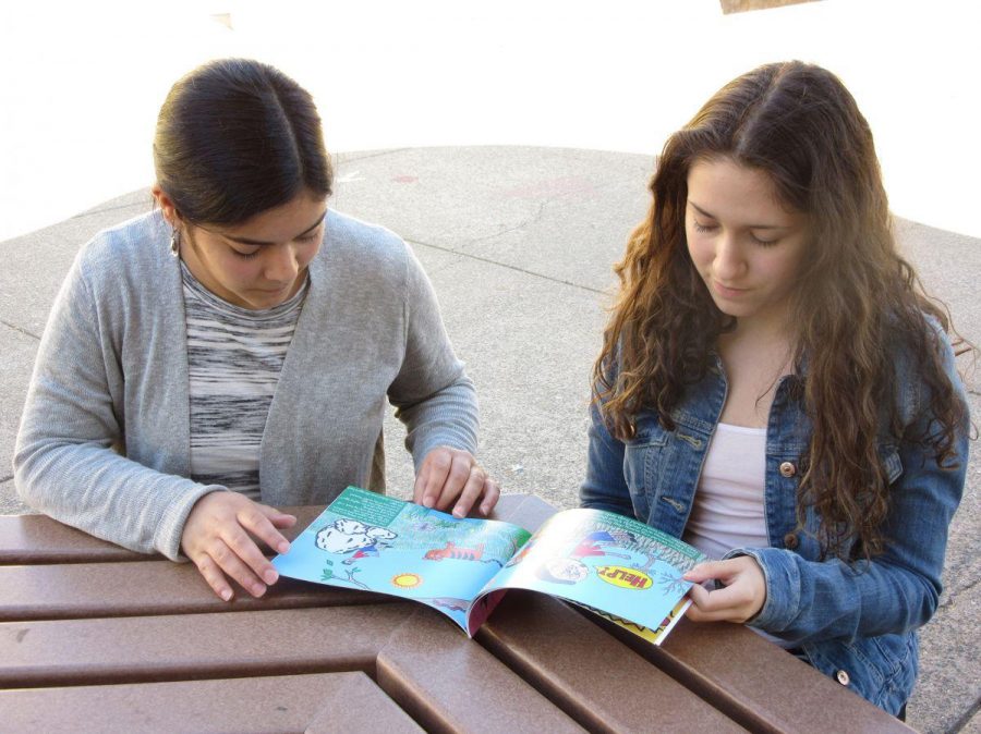 PUBLISHED JUNIOR DUO survey their book, while seated in the quad. After years of hard work their childrens picture book, African Life, is now available for purchase on Lulu.com.
