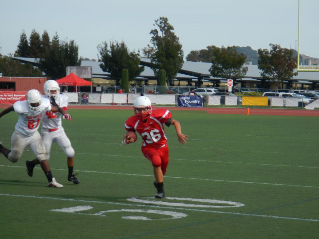 Sophomore Luigi Andrade runs the football while being pursued by San Rafael defense.
