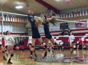 Seniors Elly Lundberg and Marguerite Spaethling jump up to block a San Rafael opponent. 